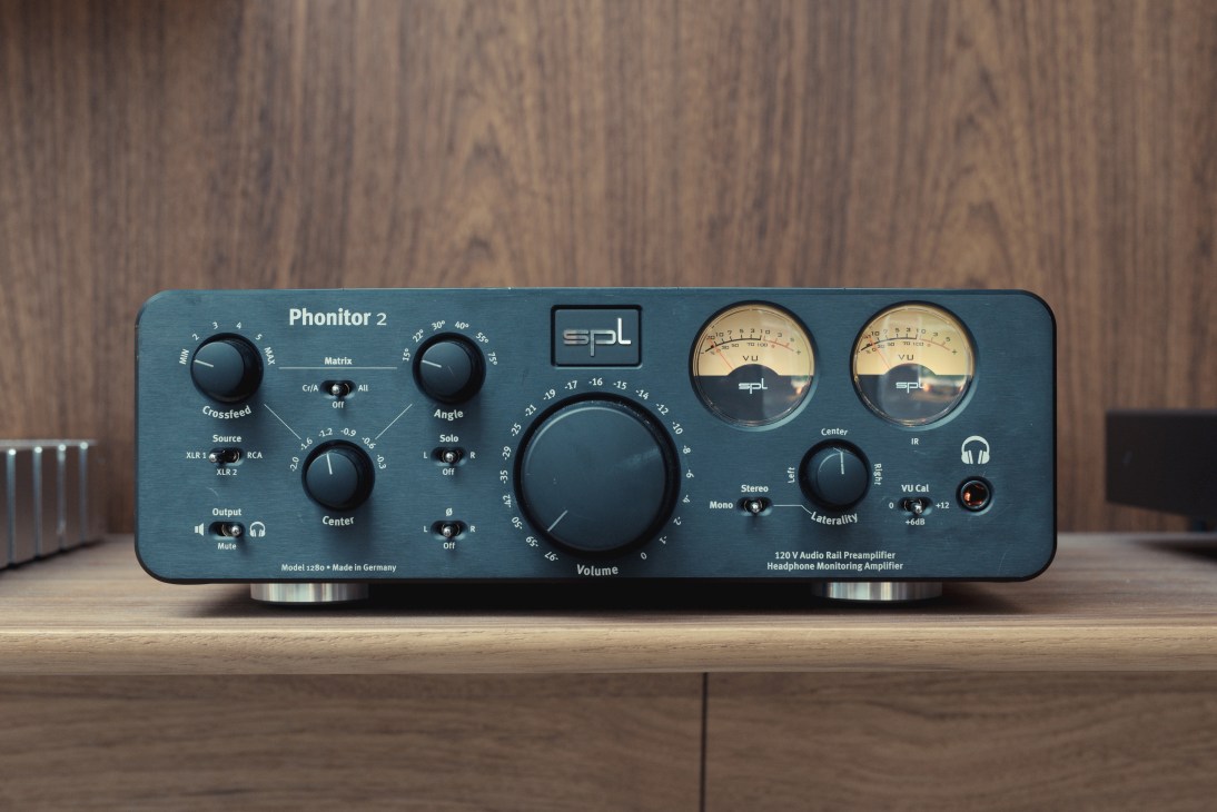 SPL Phonitor 2 headphone preamp with blue-grey faceplate, knobs, and VU meters on wooden surface.