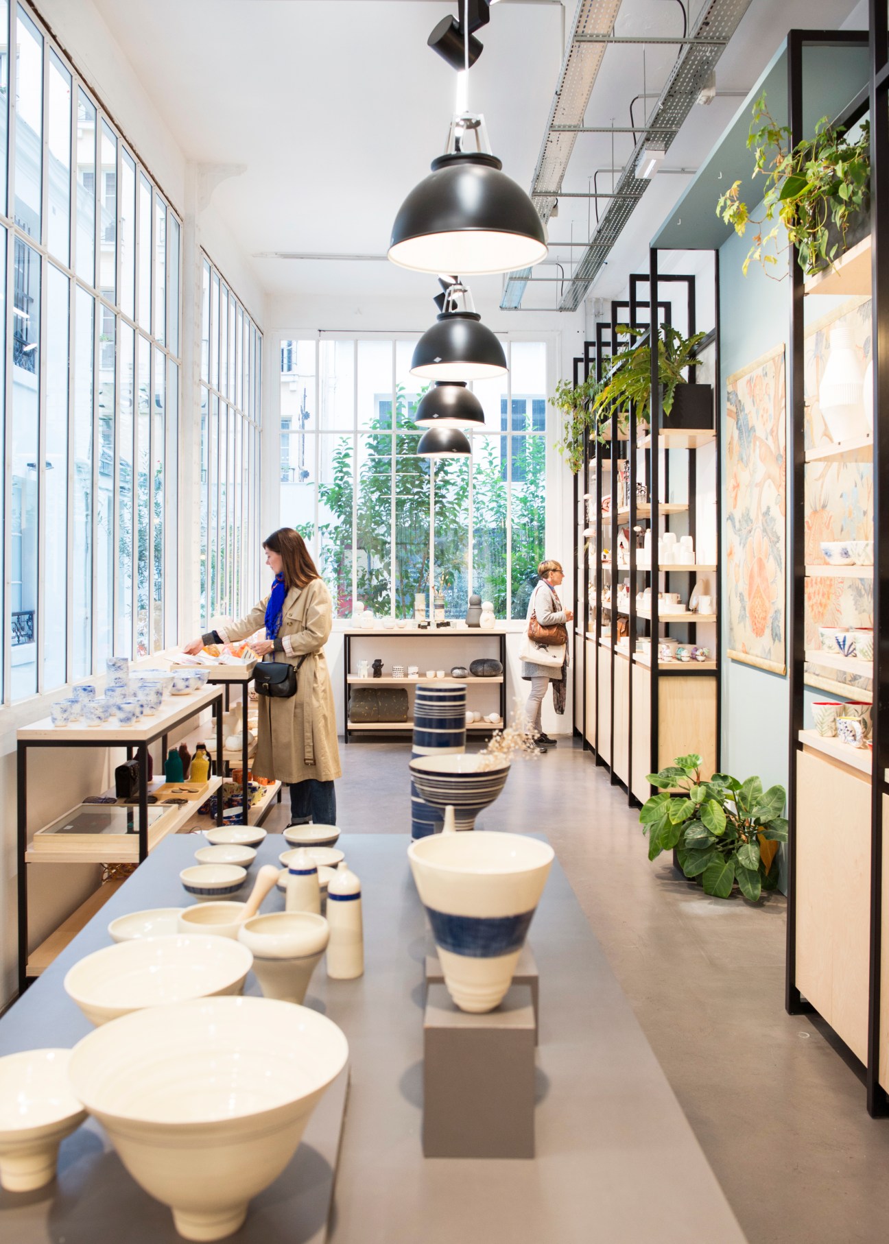 Interior of Empreintes craft marketplace in Paris with ceramic tableware displayed on tables and shelves
