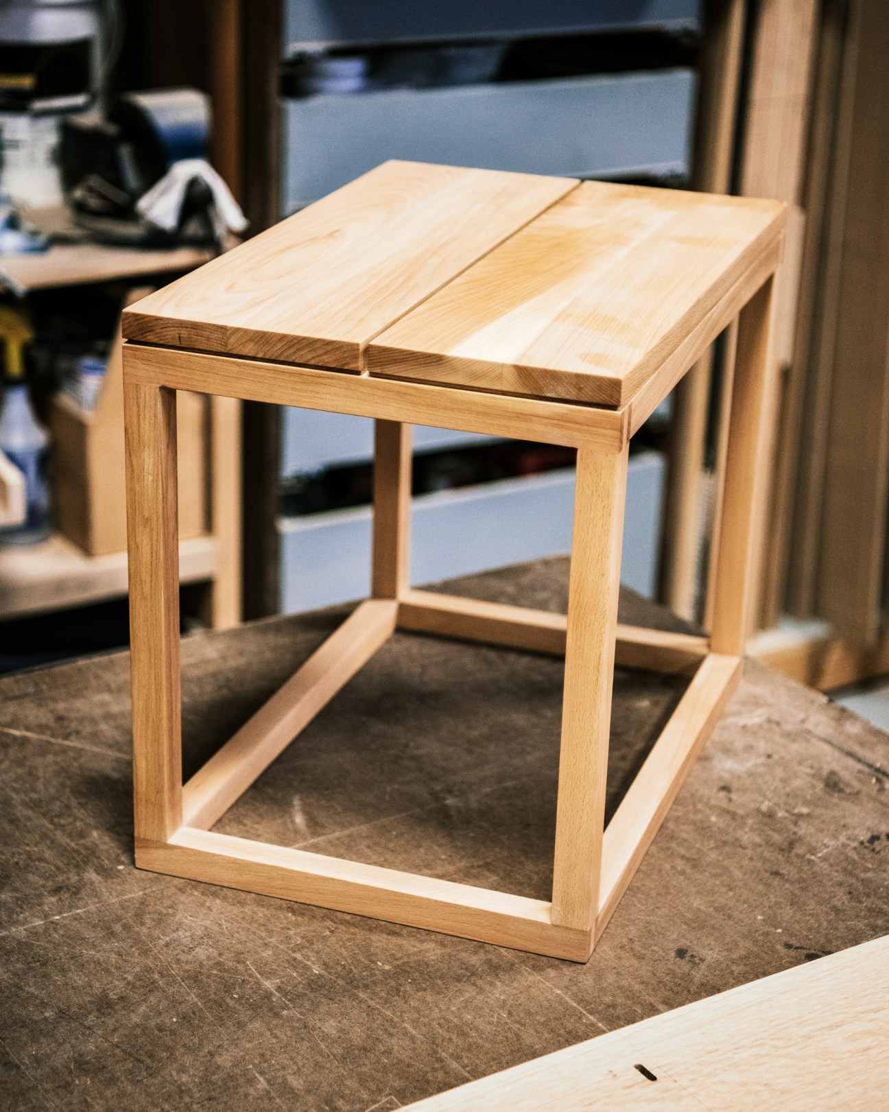 A light wood table with frame construction displaying joinery details in a workshop studio.