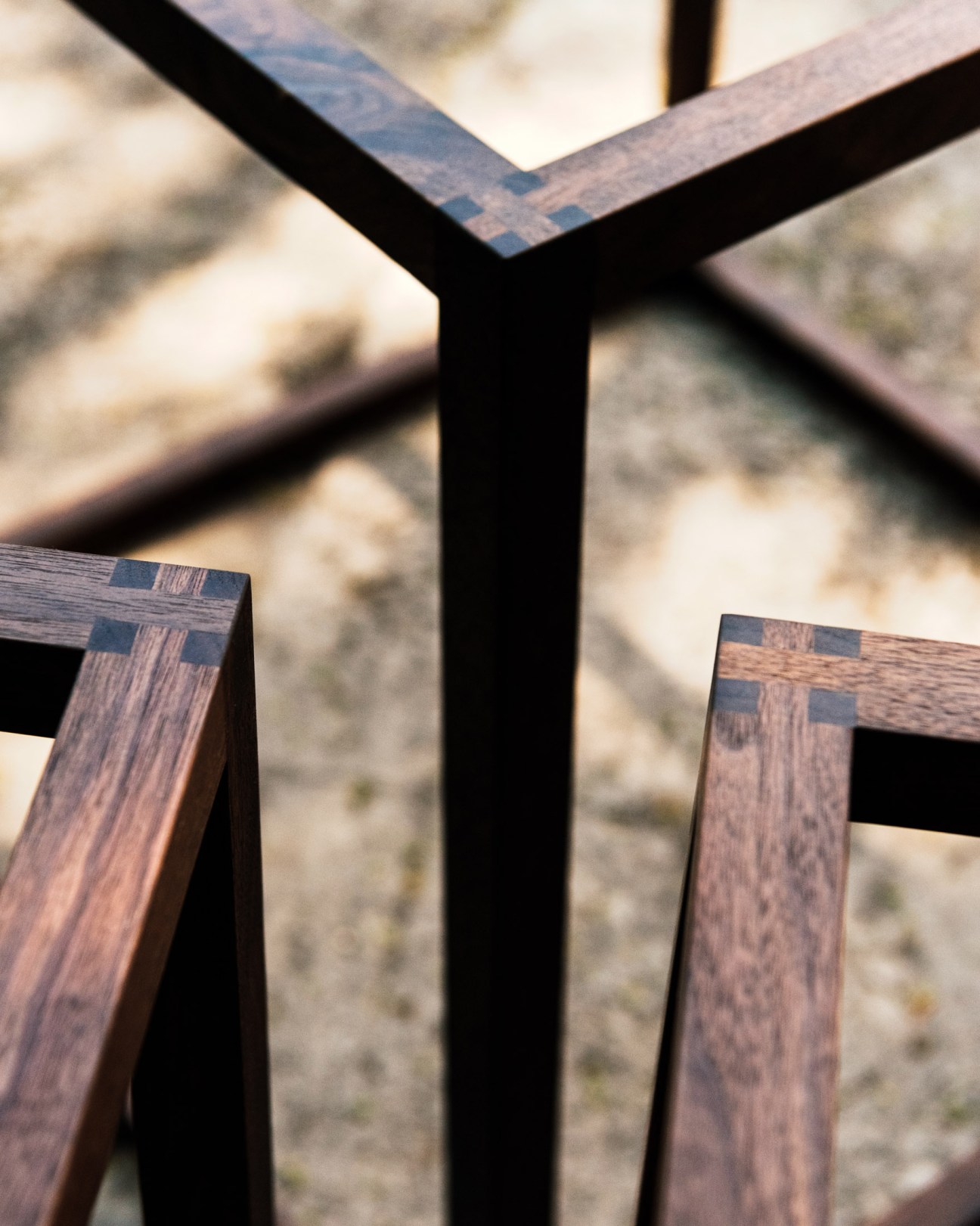 Close-up detail of wooden furniture joinery showing brass inlays and wood grain.