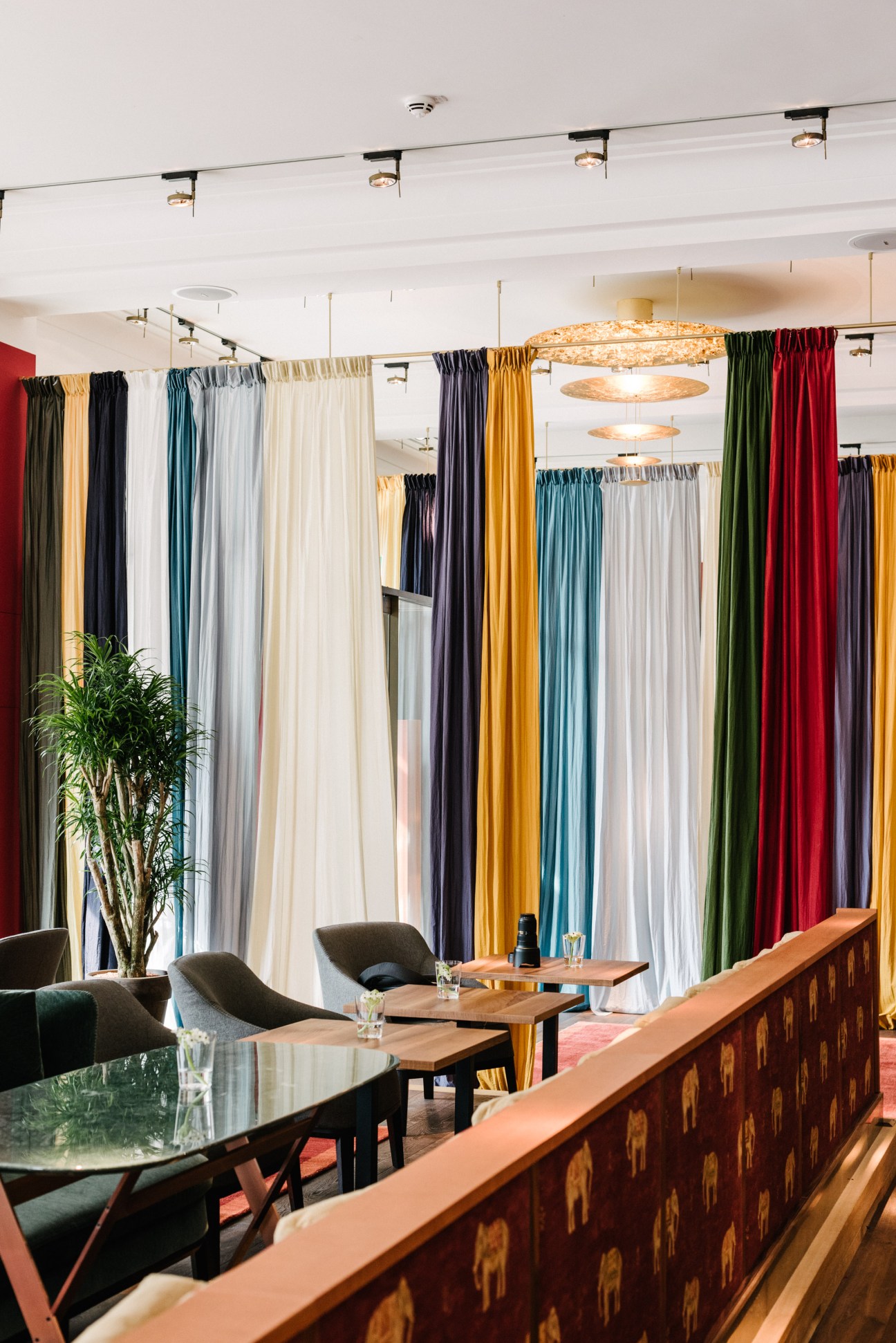 Orania Berlin lobby with colorful curtains, modern furniture, and elephant-patterned counter detail.