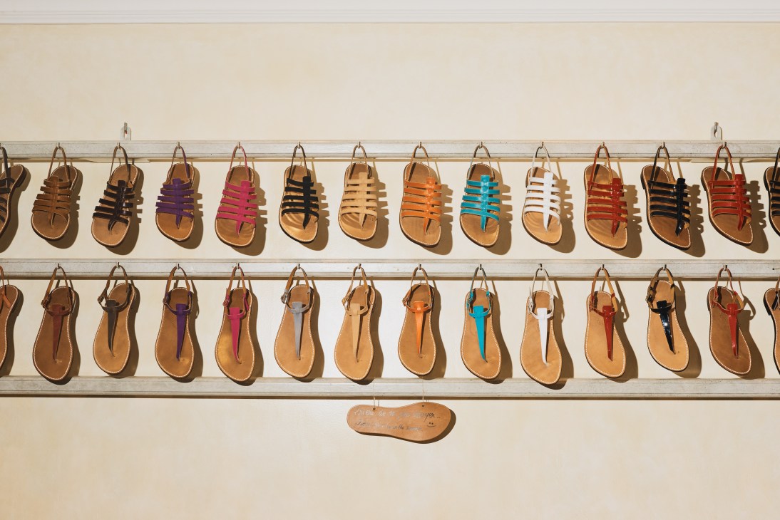 Colorful strapped sandals displayed on wall shelves at Rondini sandal shop.