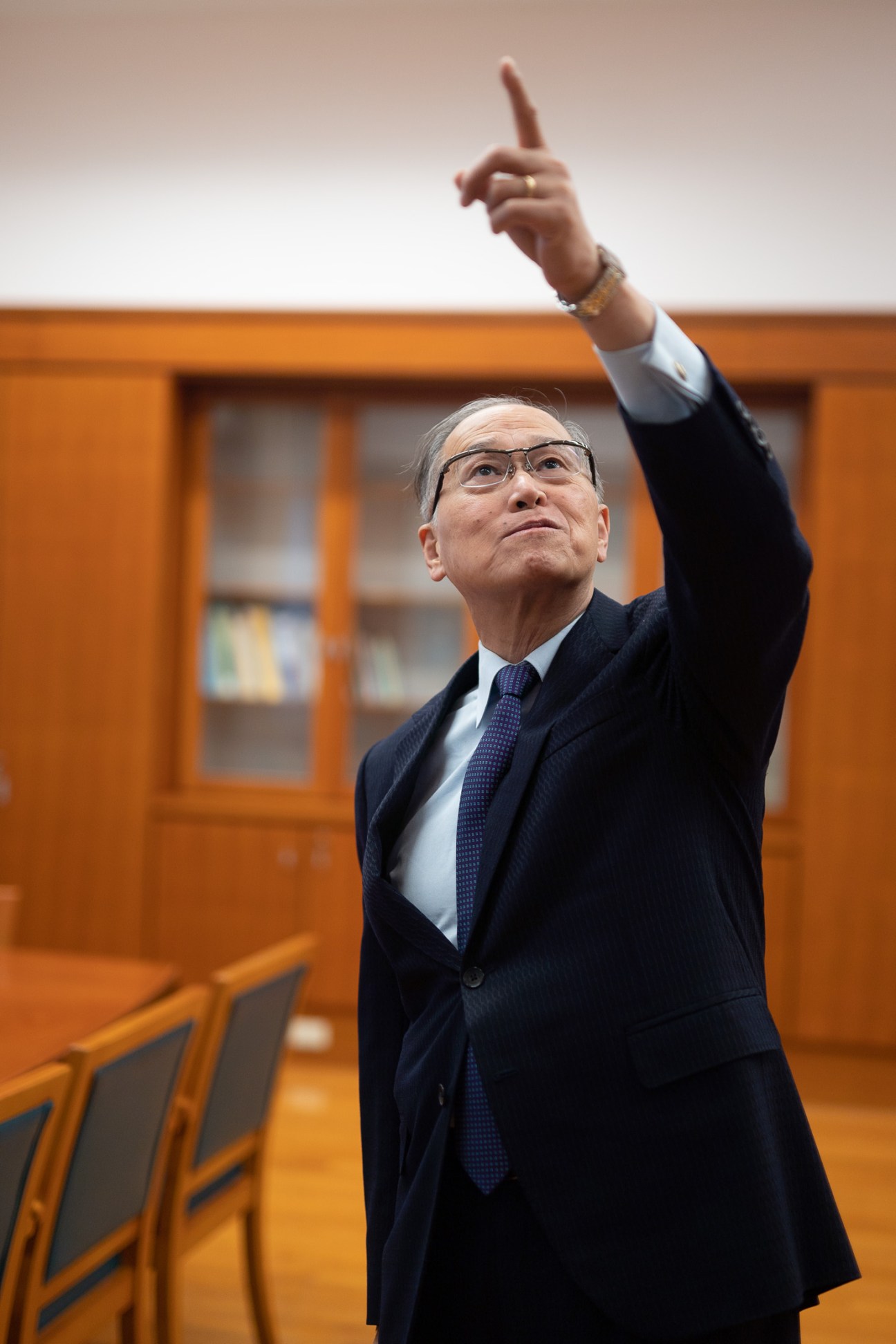 David Lee, former foreign minister and secretary-general of the National Security Council, pointing upward in an orange-walled room.