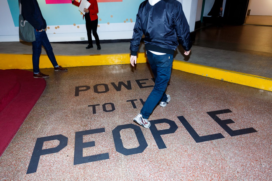 Person walking across floor with "Power to the People" text at Taiwan's Presidential Office Building.