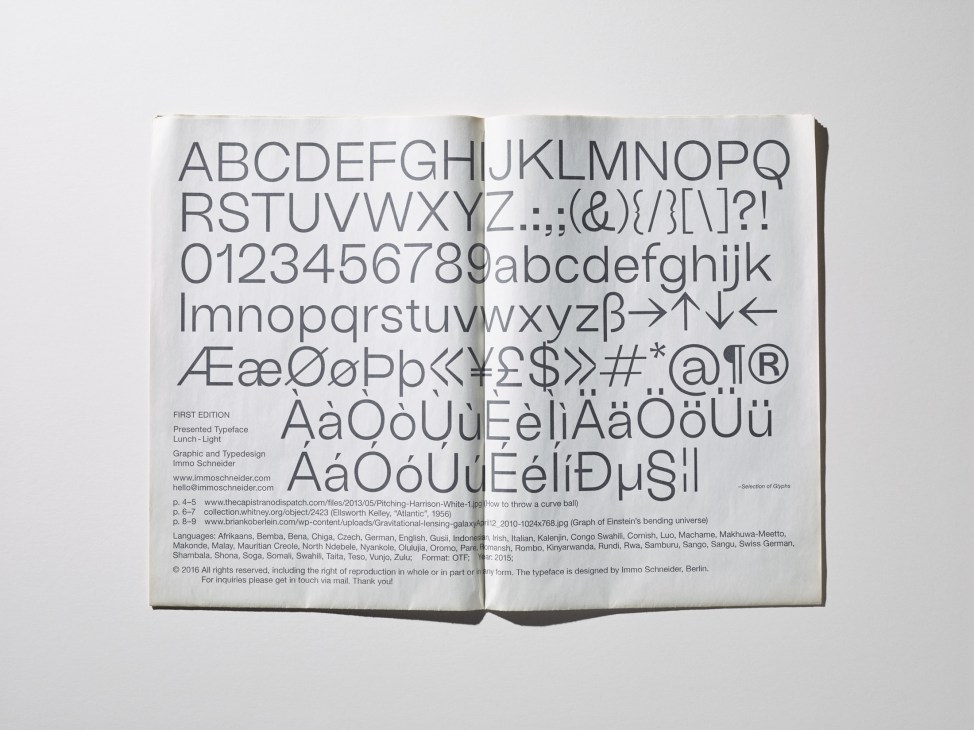 Open book displaying an alphabet of letters and numbers in a sans-serif typeface with special characters and accents.