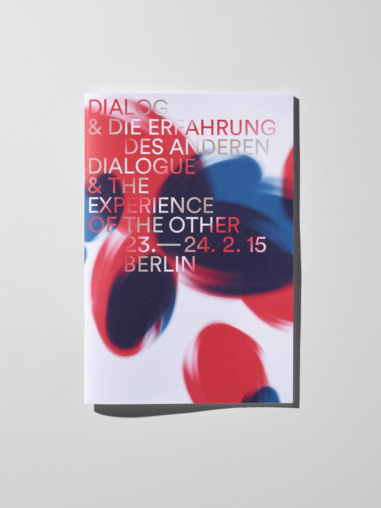 White leaflet with red and blue geometric shapes designed by Bureau David Voss.