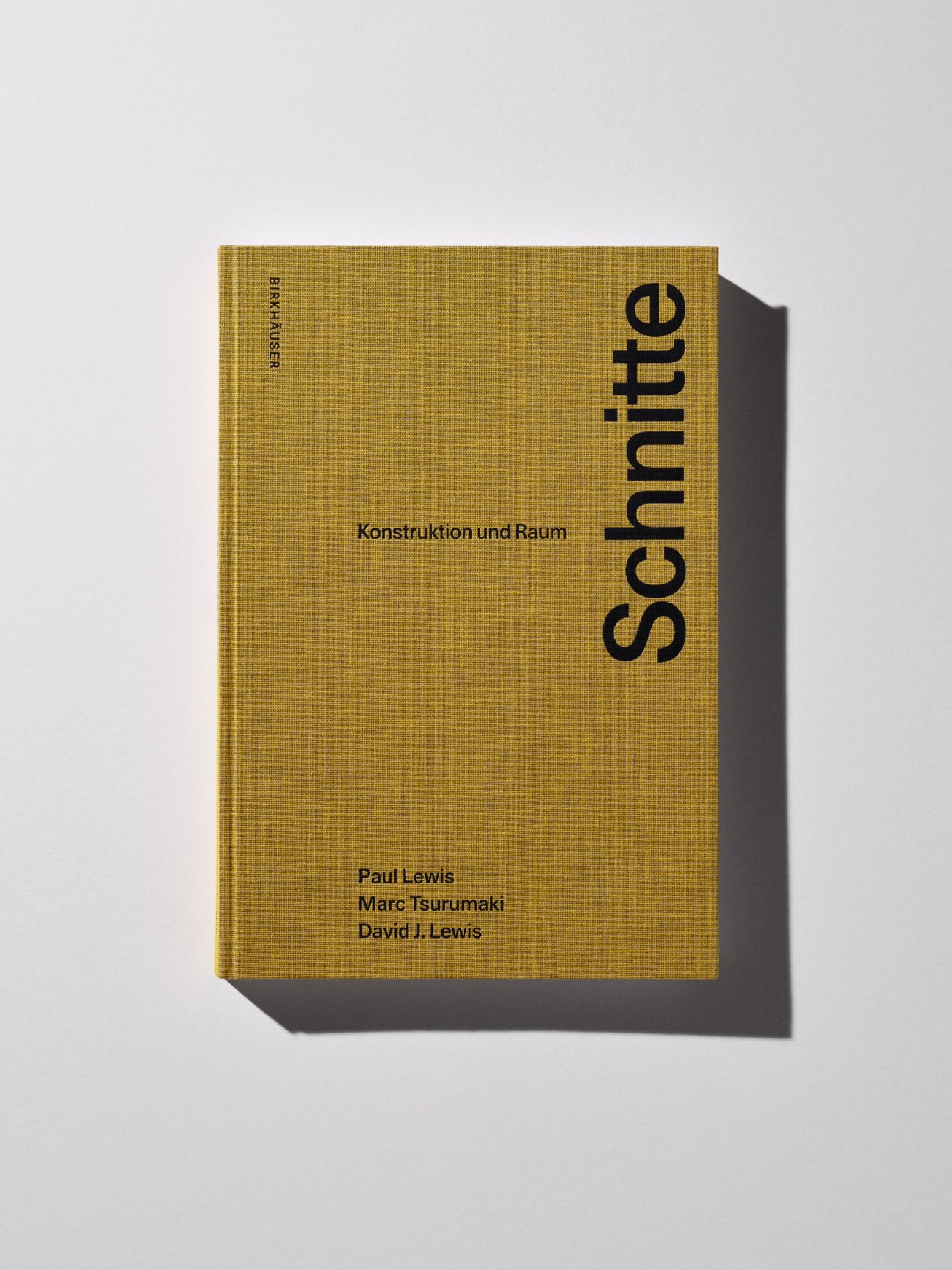 Gold hardcover book titled 'Schnitte: Konstruktion und Raum' by Paul Lewis, Marc Tsurumaki, and David J. Lewis.