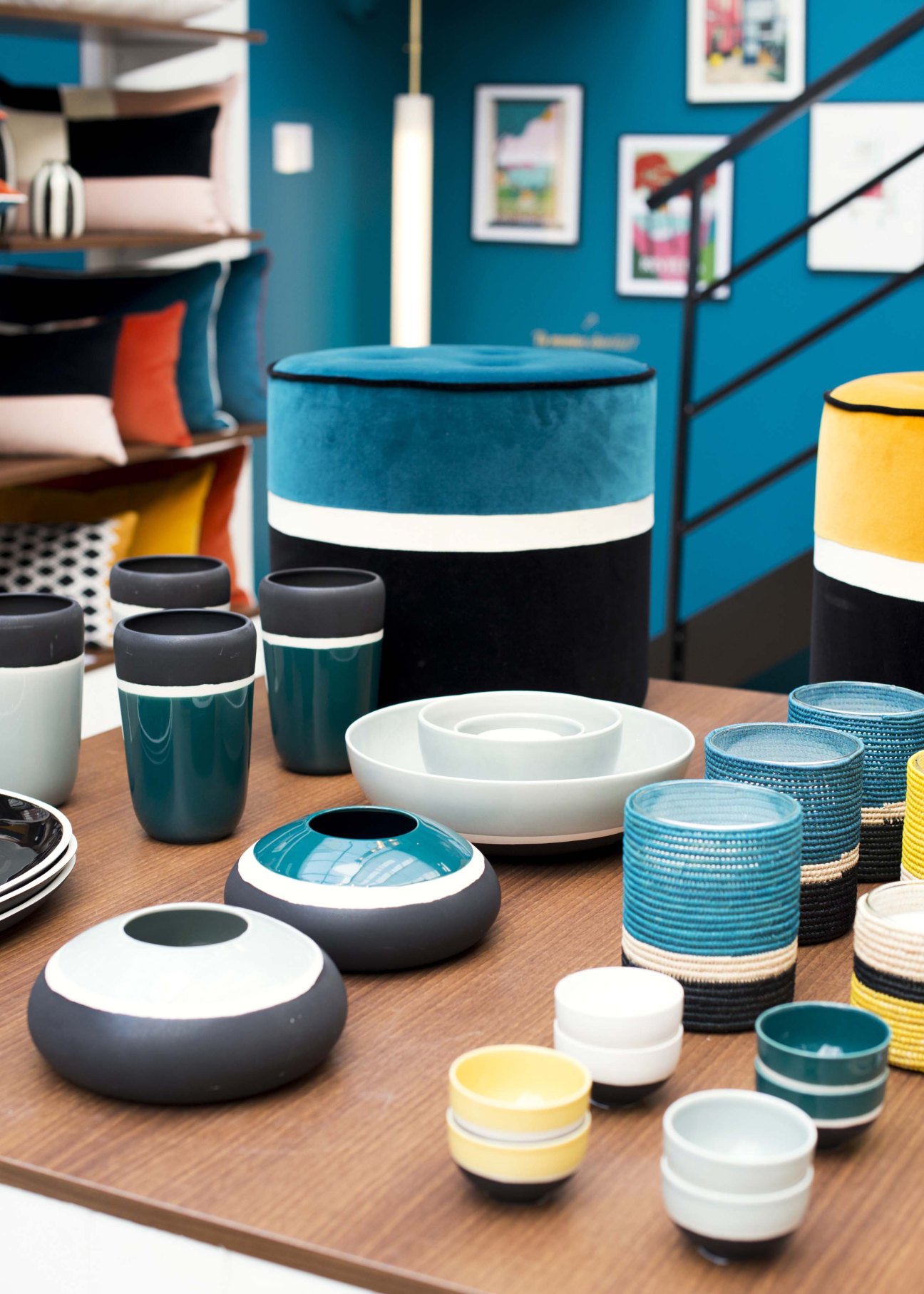 Striped velvet pouf in bright blue and yellow 1970s-inspired design displayed in shop setting