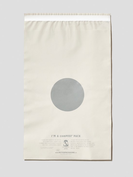 Cream-colored compostable jiffy bag with grey circle and text explaining it is made from sustainable plants and compostable resin.