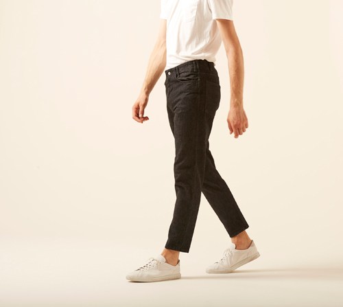 Man wearing 806t jeans by Westoveralls in indigo denim with white t-shirt and sneakers.
