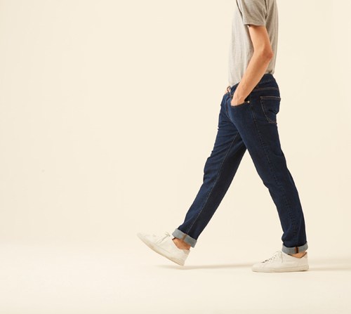 Person wearing Brooklyn denim by Blauer USA in dark blue with white sneakers and light shirt