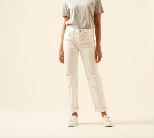 Woman wearing cream-colored 1997 jeans by Acne Studios with straight-leg cut and minimalist design.