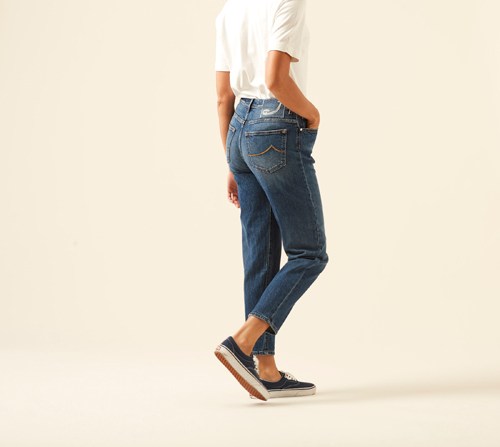 Person wearing Kimmy Jewel jeans by Jacob Cohën in dark blue denim with white top and black sneakers