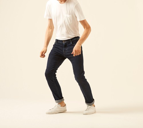 Man wearing J622 Eccellenza jeans by Jacob Cohën in dark indigo with white t-shirt and cream sneakers.