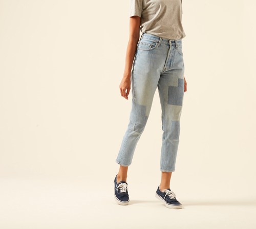 The Detroit jeans by Atelier & Repairs shown on model wearing beige shirt and navy sneakers.