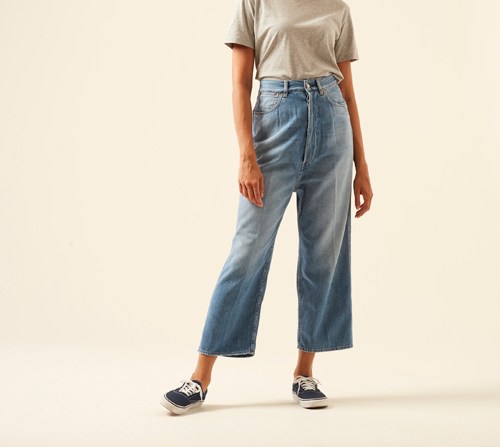 Woman wearing Breezy jeans by Golden Goose in light wash with distressed detailing and relaxed fit