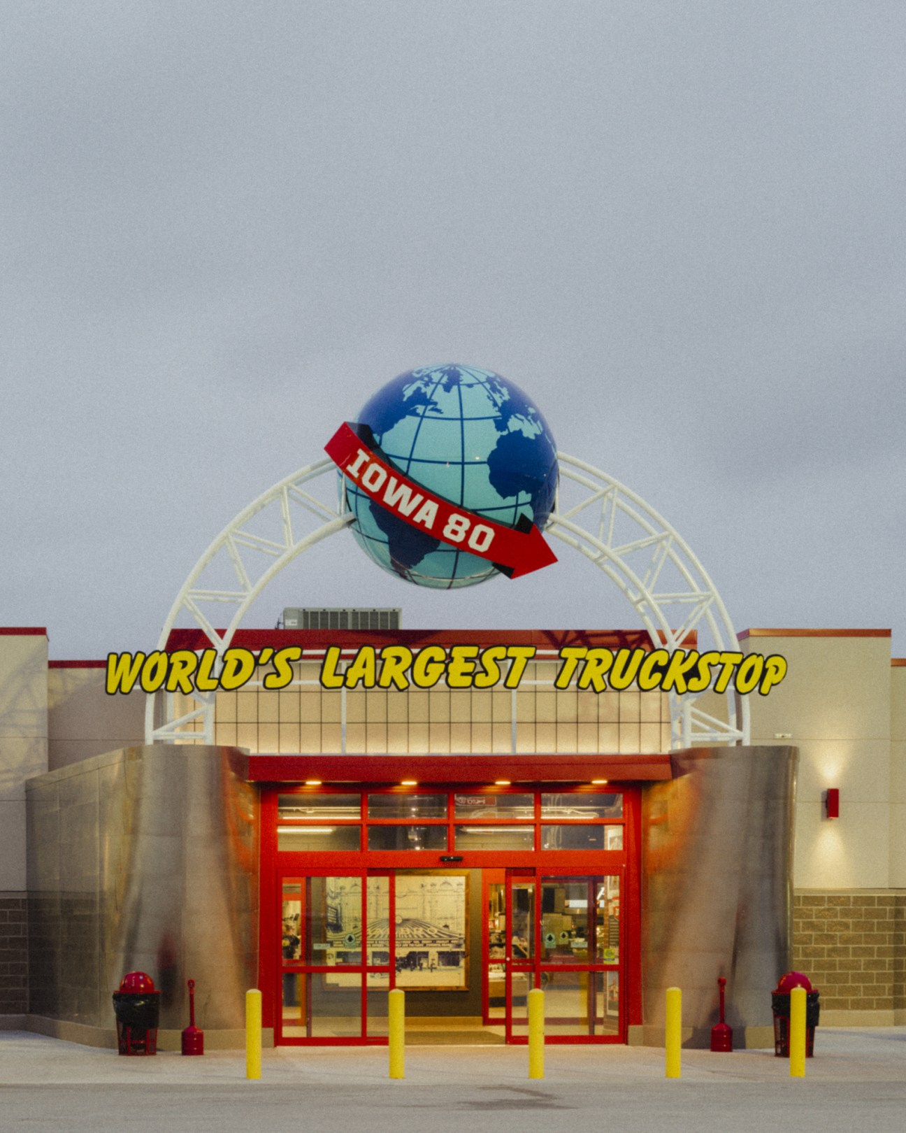 Iowa 80 truckstop entrance with globe and arrow sign reading 'World's Largest Truckstop'