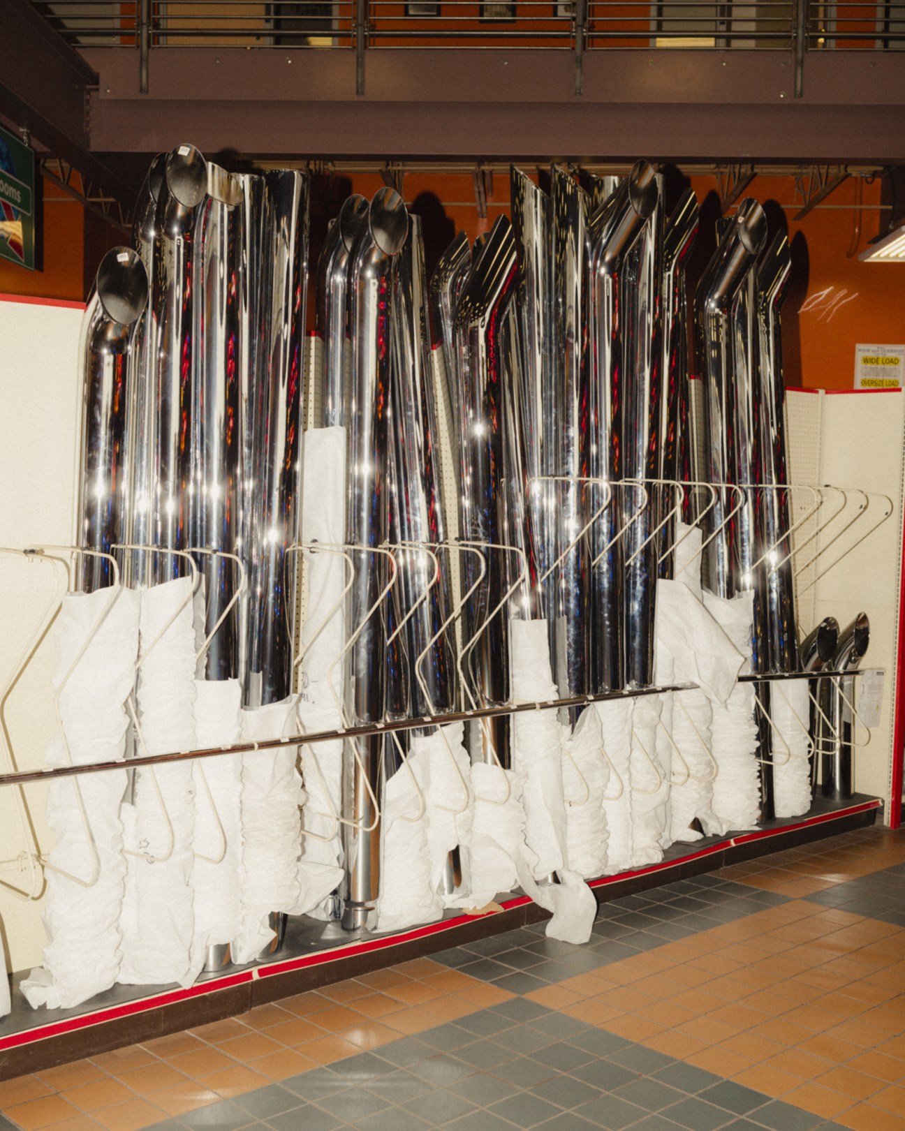 Chrome exhaust stacks displayed on racks with white towels at Iowa 80's Super Truck Showroom.