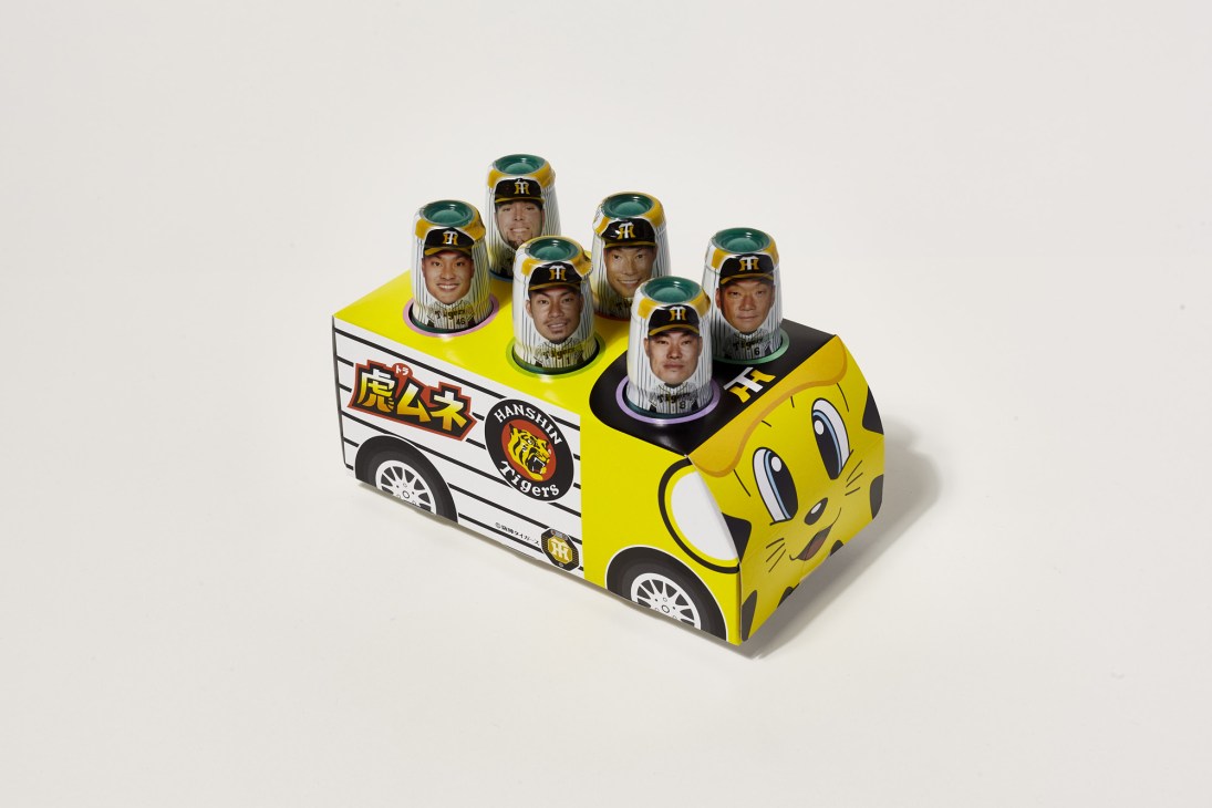 Hanshin Tigers themed six-pack beer carrier shaped like a yellow bus with player head caricatures on top.
