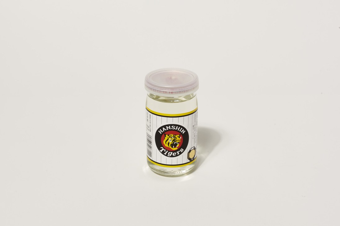 Hanshin Tigers branded sake bottle with clear lid against neutral background.