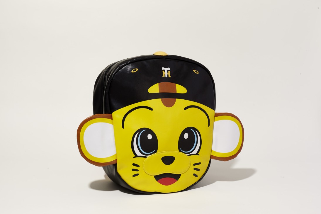 Yellow cartoon tiger mascot backpack with black cap and smiling face against white background.