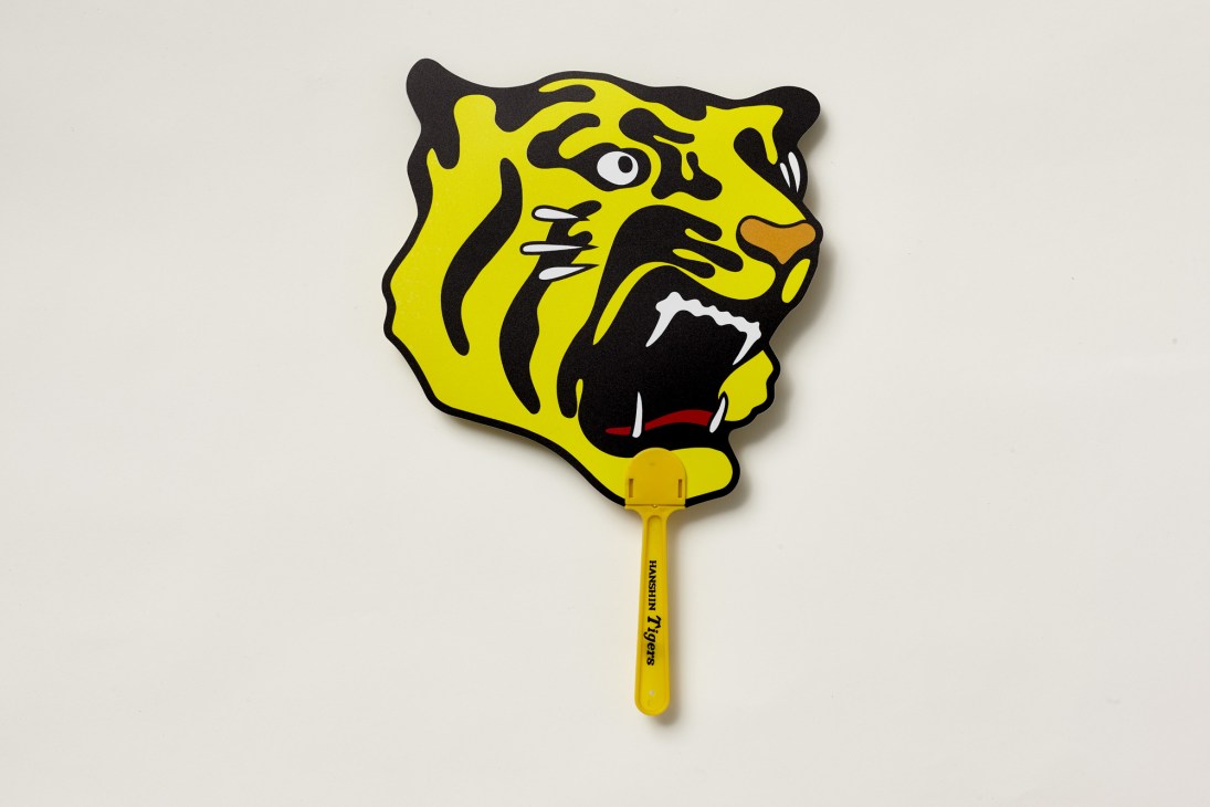 Yellow tiger-shaped fan with black stripes and white details featuring the Hanshin Tigers baseball team logo.
