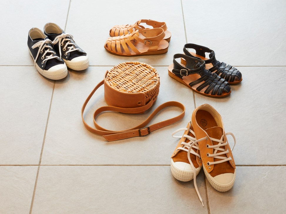 Rosa Mosa leather sandals, canvas trainers, and woven willow basket bag arranged on white wooden floor