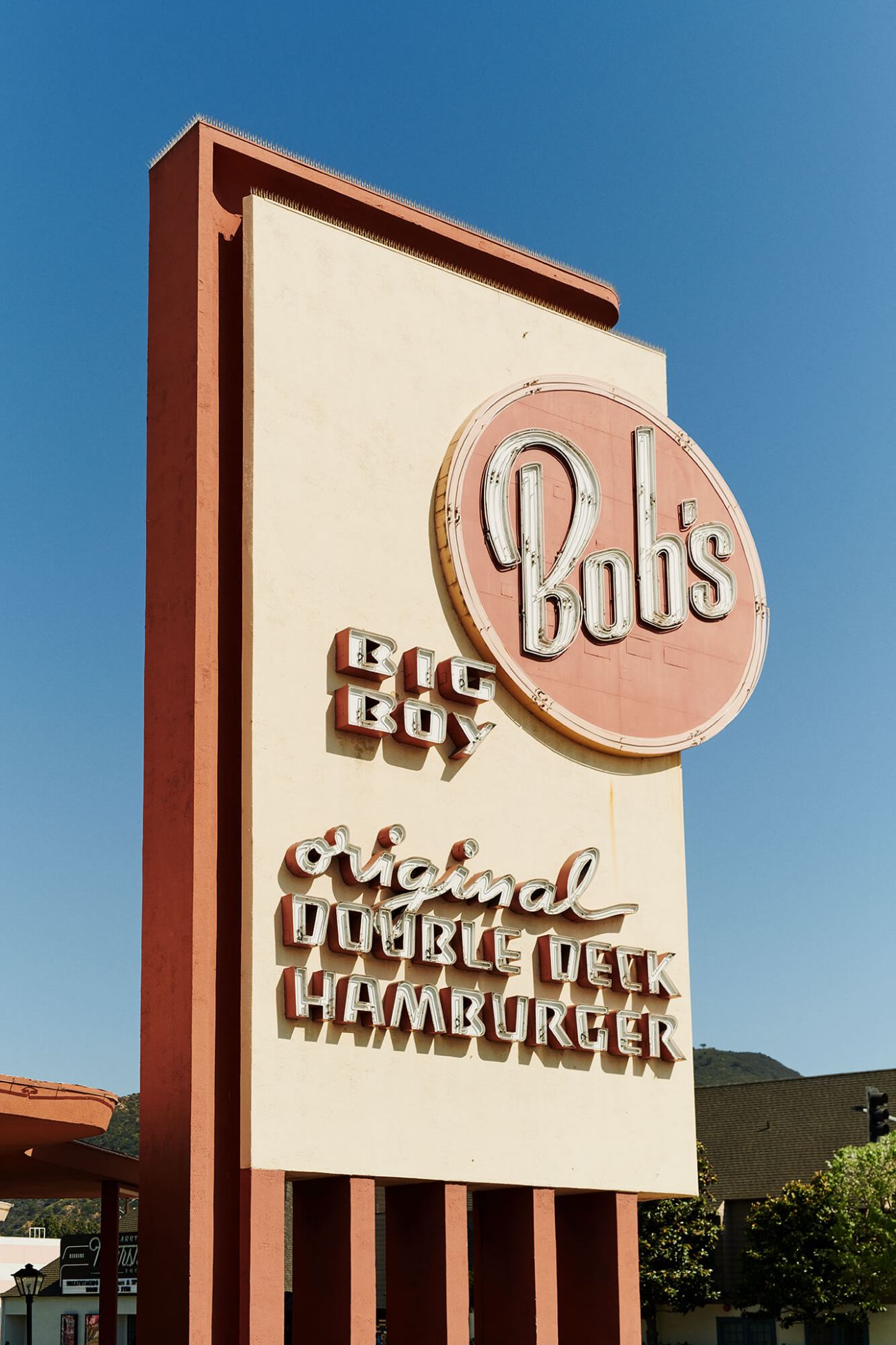 Bob's Big Boy vintage neon sign featuring the restaurant's iconic mascot and double-deck hamburger branding on a mid-century pole sign.