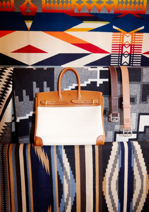 Handmade leather bag and belts by Christophe Berti displayed on colorful patterned textiles