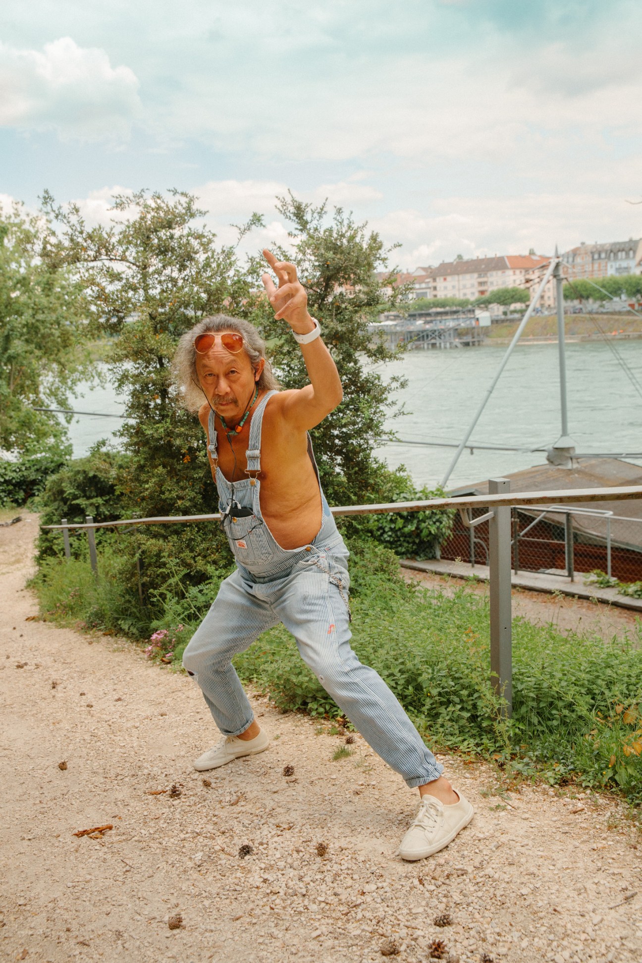 Performance artist David Megaboom poses theatrically on a path beside the Rhine in Basel.