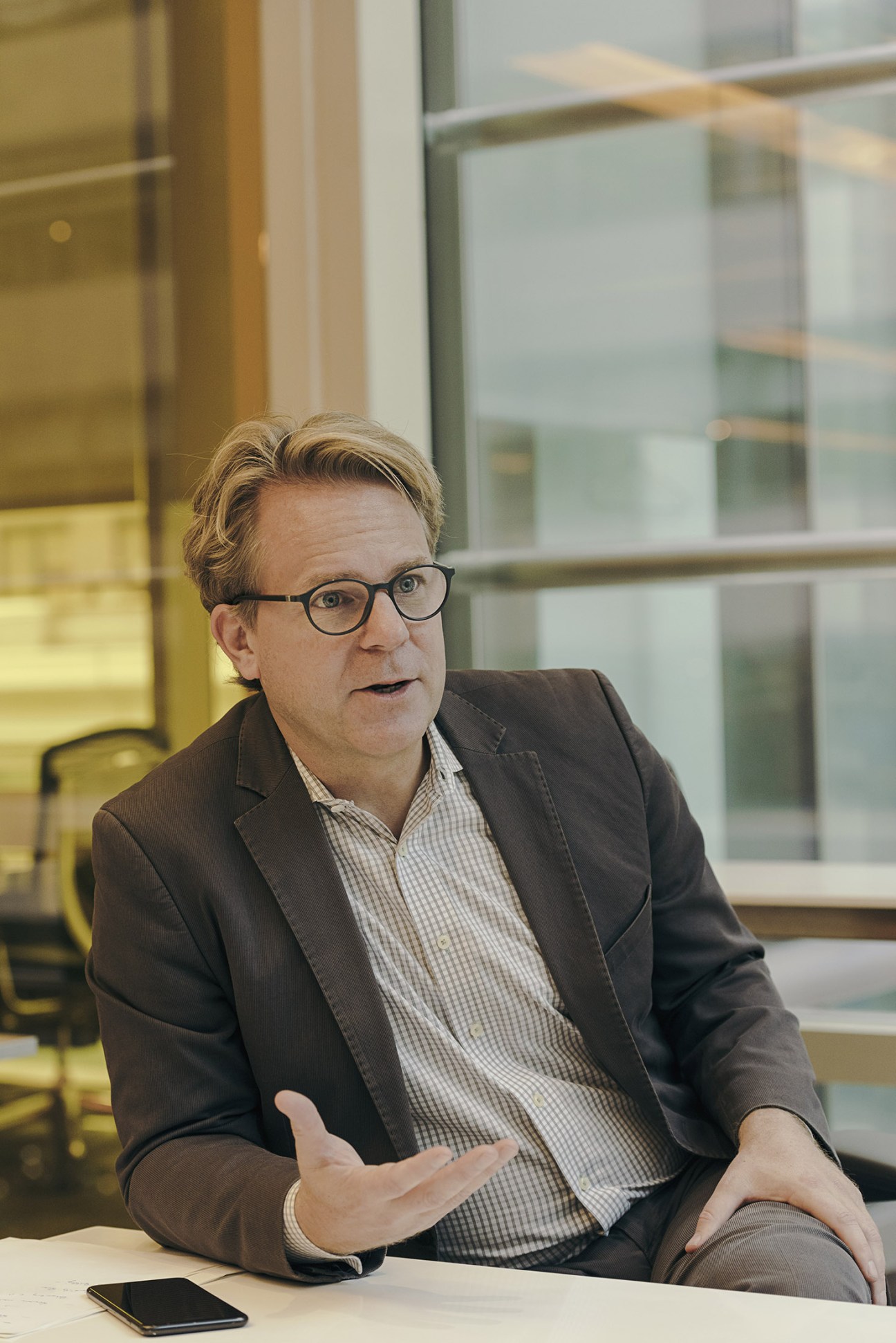 Justin B Smith, CEO of Bloomberg Media, wearing glasses and a dark blazer, gesturing while speaking.
