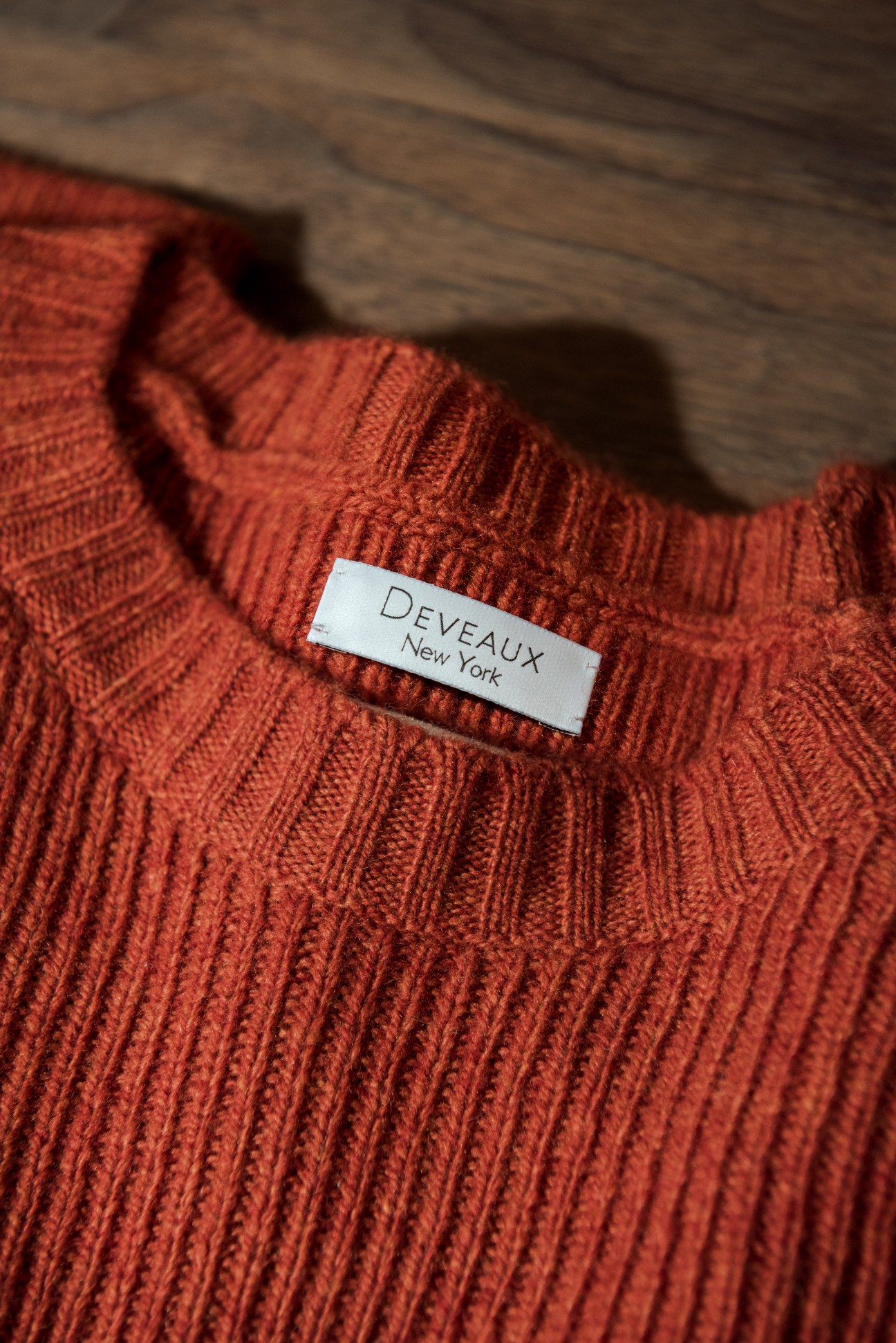 Deveaux New York label on a burnt orange ribbed cashmere sweater detail.