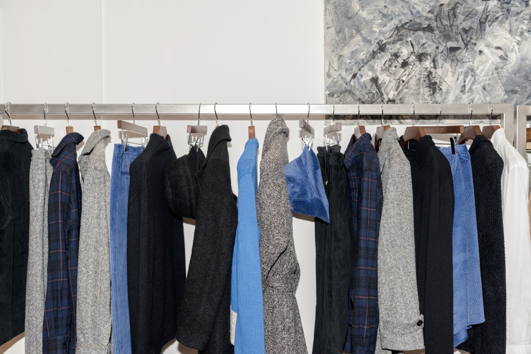 Deveaux clothing collection hanging on a rail displaying moody blues and greys for the new women's line.