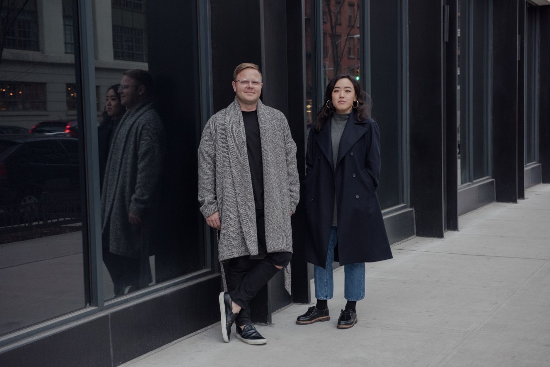 Matthew Breen and Andrea Tsao, Deveaux co-founders, stand on a New York street wearing the brand's signature minimalist designs.