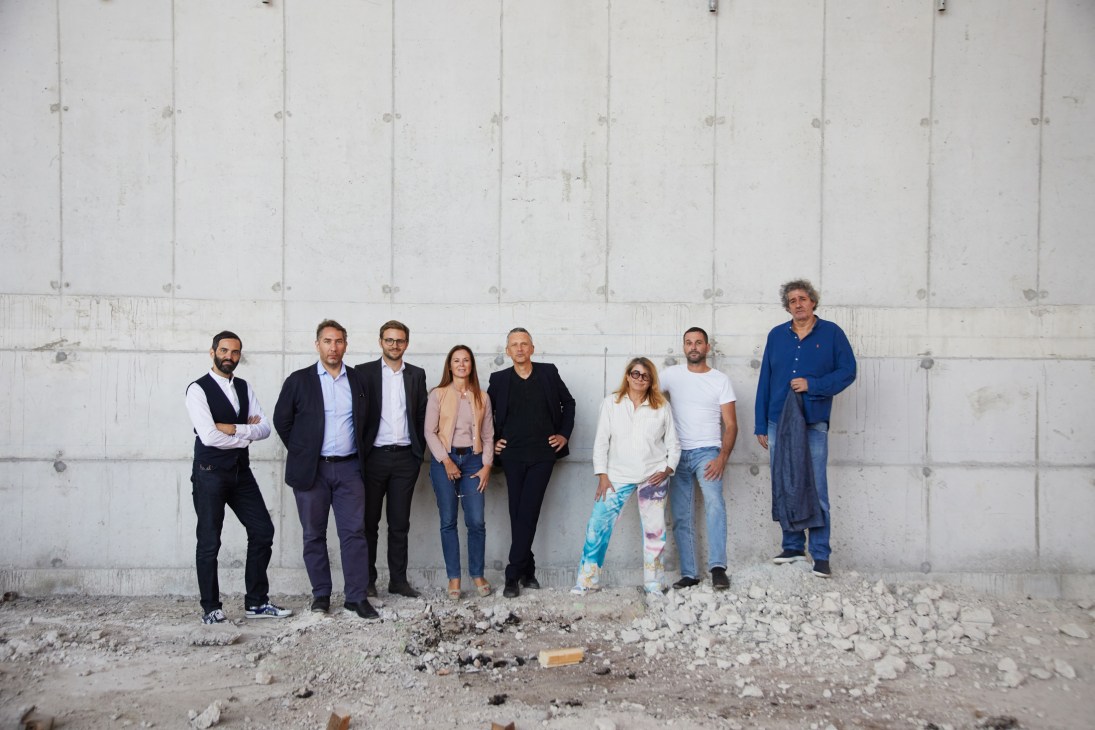 Group photo of eight Parisian art luminaries standing together in the gallery space