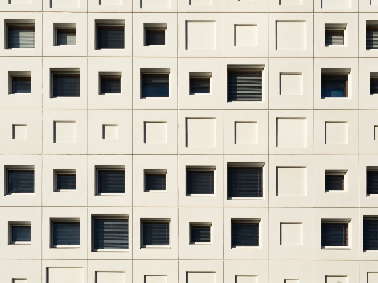 Cream-colored facade of Jätkäsaari School with a grid of square windows and angular balconies.
