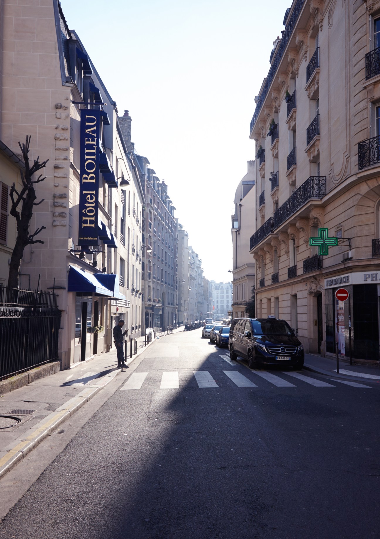 Parisian street in the 16th arrondissement with Hotel Boileau sign and classical Haussmann buildings.