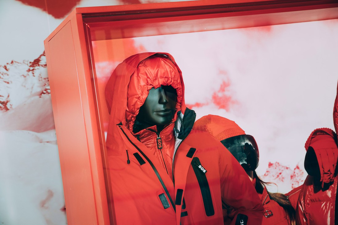 Mannequin wearing a red Aztech Mountain puffer jacket with black accents in a display case.