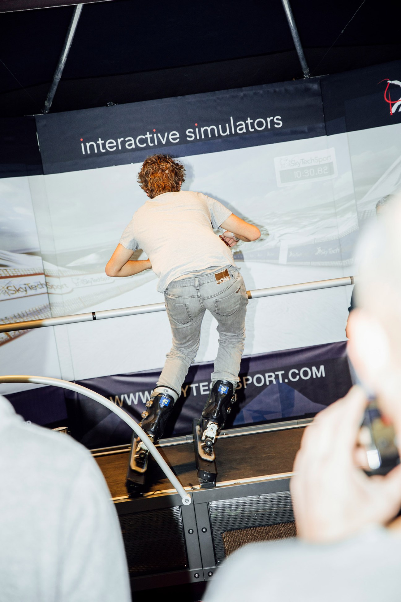 Person testing ski boots on an interactive simulator at Ispo sportswear fair