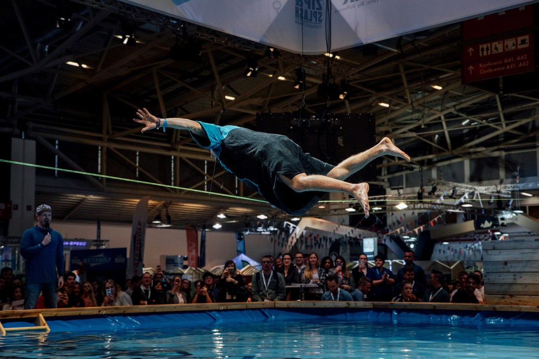A man performs a diving demonstration into a pool at the Ispo sportswear fair in Munich.