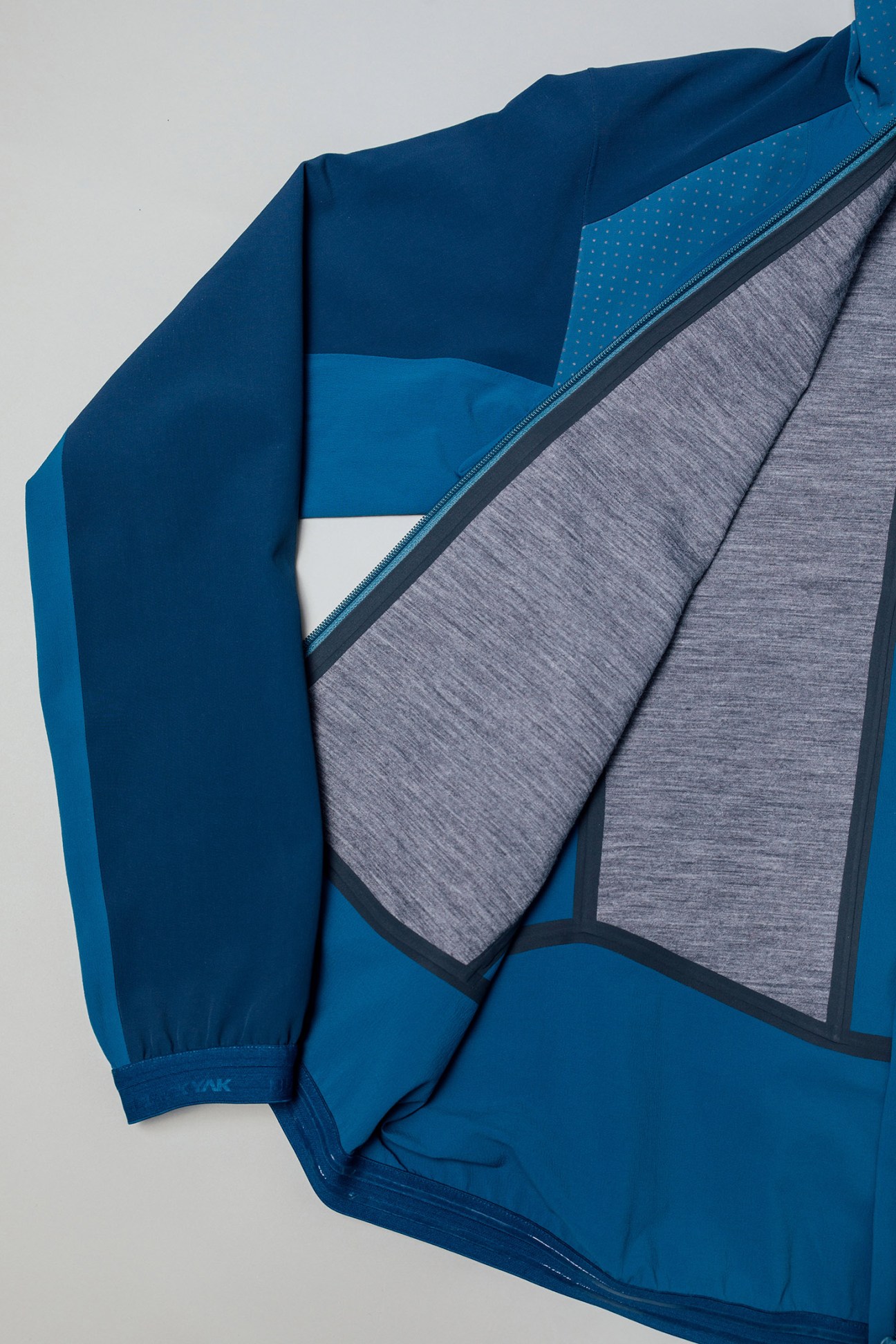 Blue lightweight jacket by Black Yak with gray lining and ventilation details exposed.