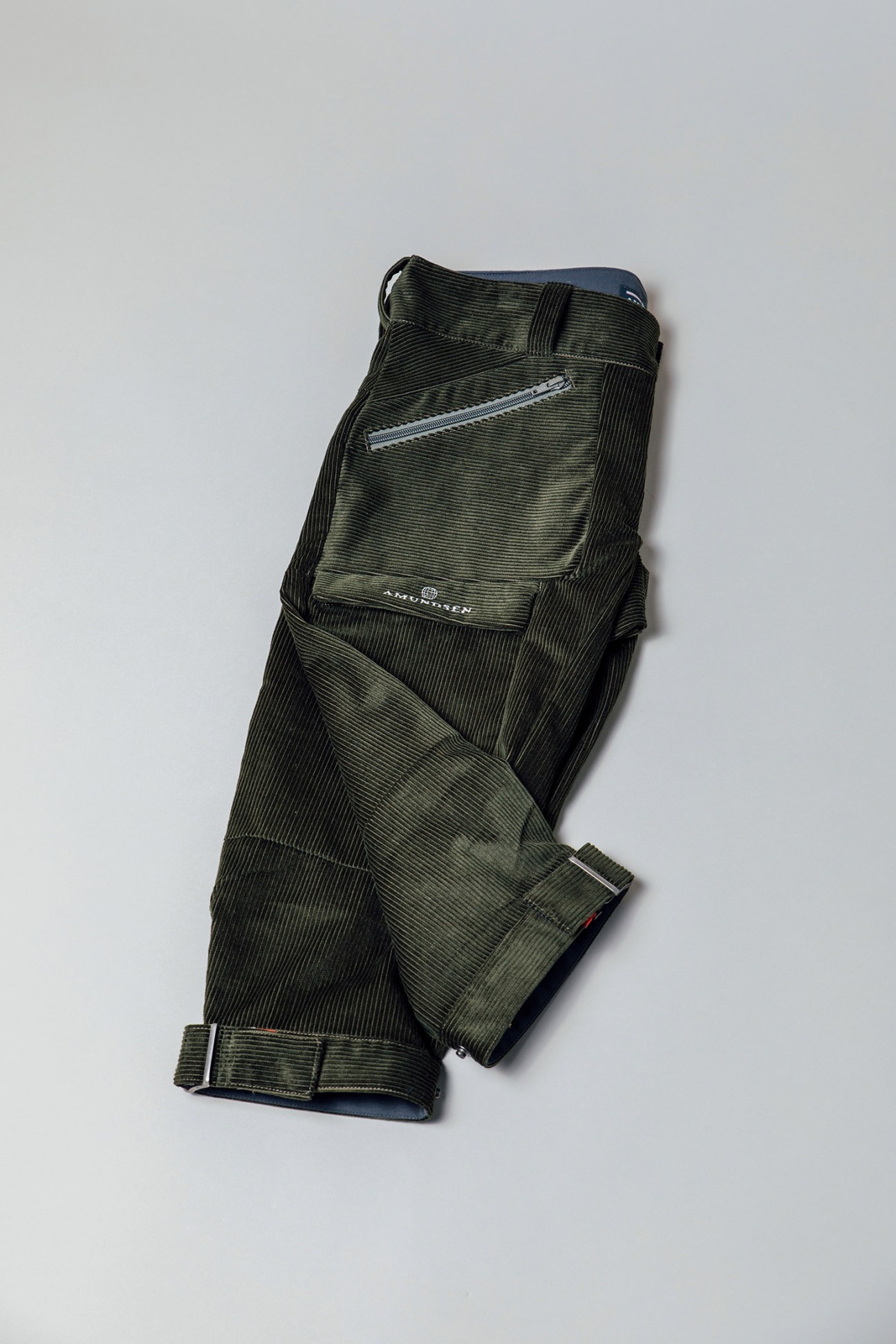 Olive and black corduroy knickerbockers by Amundsen laid flat against a gray background.