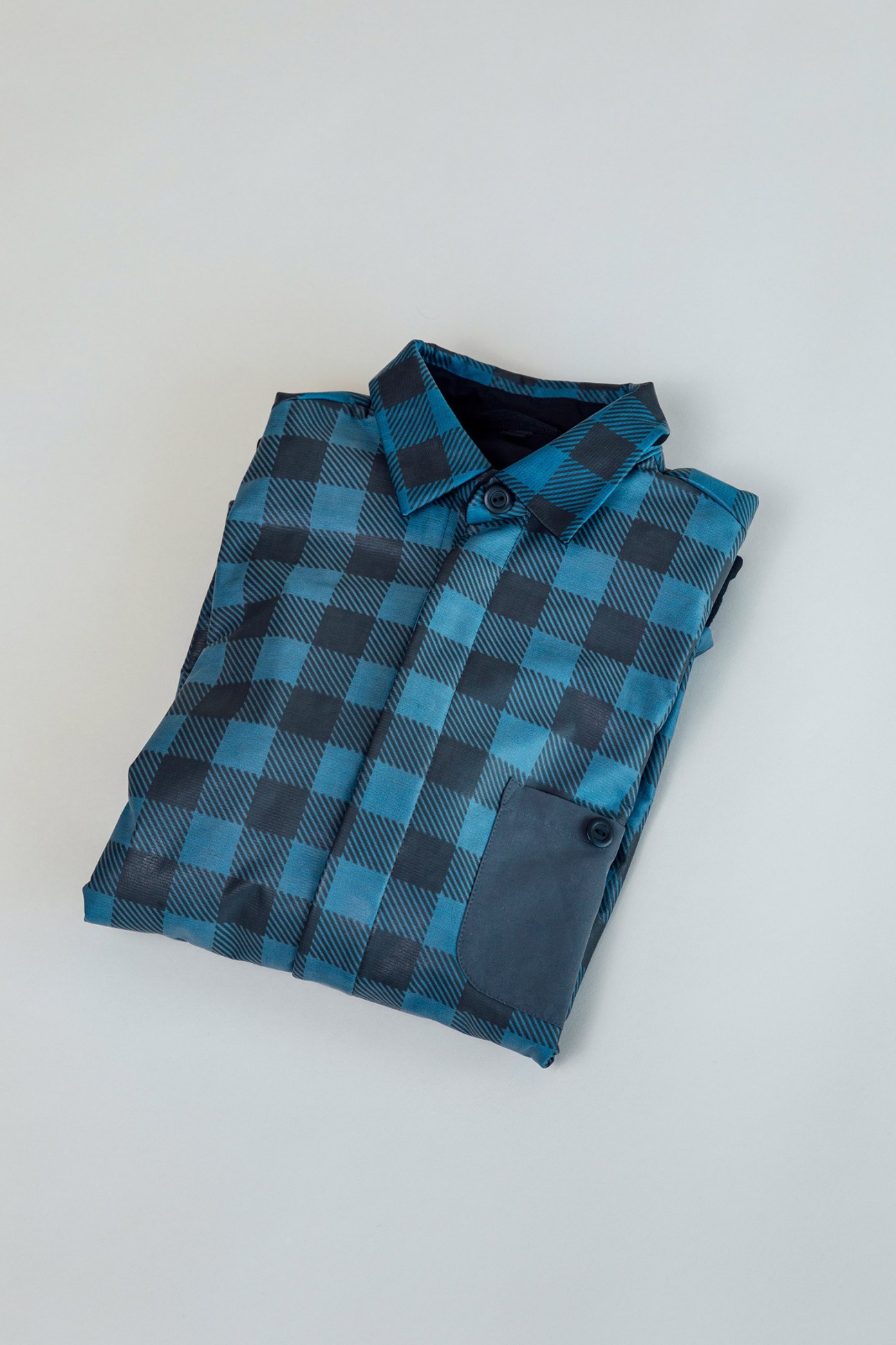 Blue and charcoal plaid-patterned quilted shirt from Gore displayed on white background.