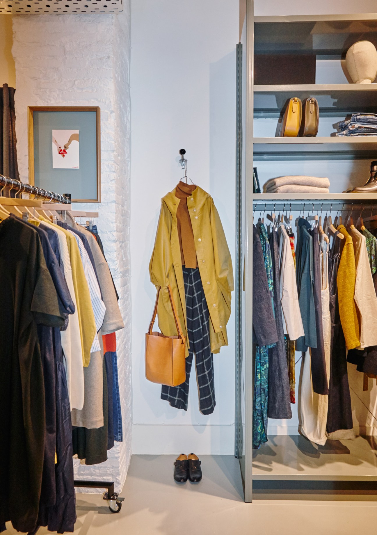 Rendez-vous womenswear store interior showing styled outfit display with yellow coat, plaid trousers and tan bag on mannequin.