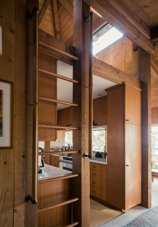 Wooden ladder leading to an elevated lounging area inside Peter Jenny's Sea Ranch home