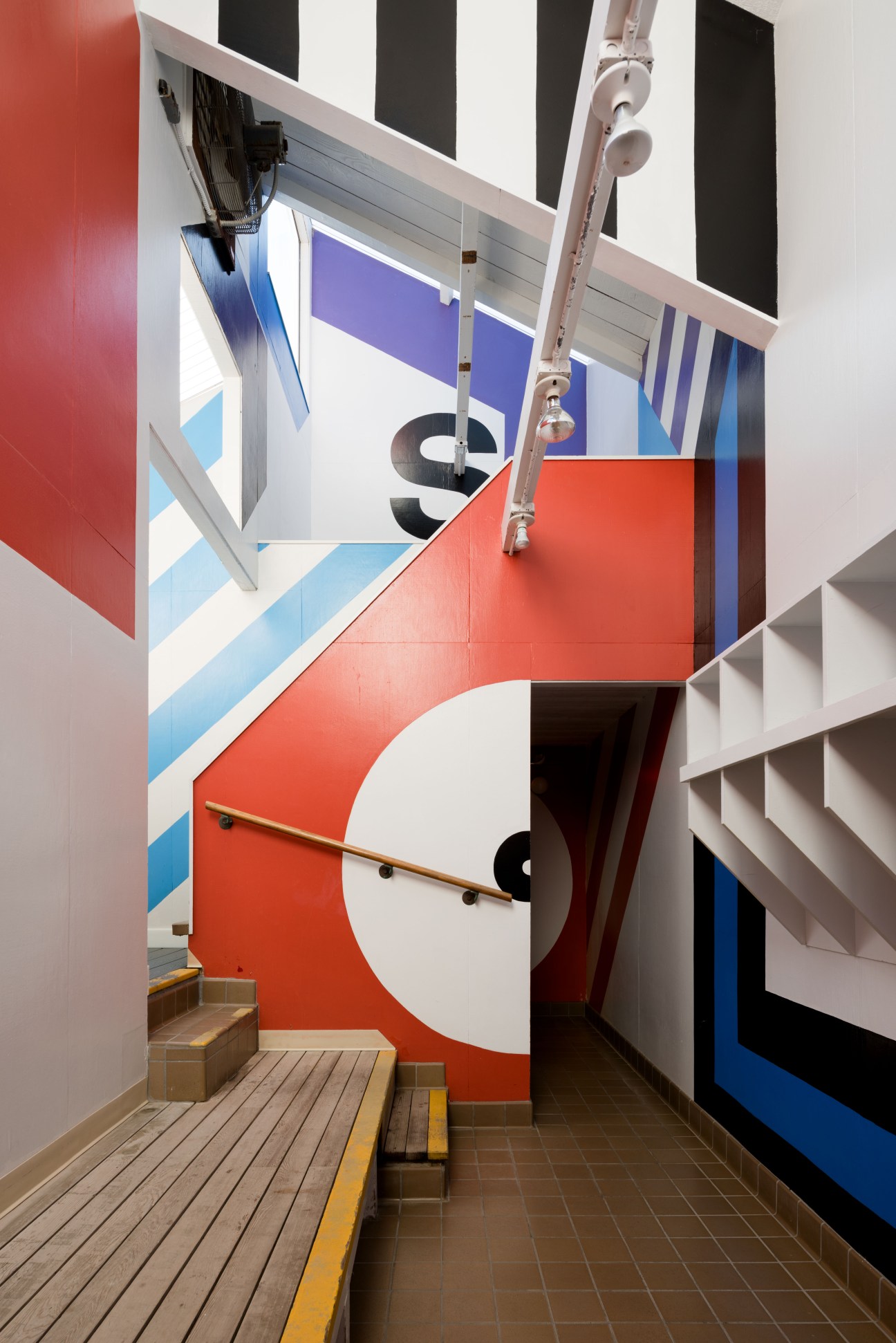 Bold geometric supergraphics with red, blue, and white shapes designed by Barbara Stauffacher Solomon in pool changing rooms.