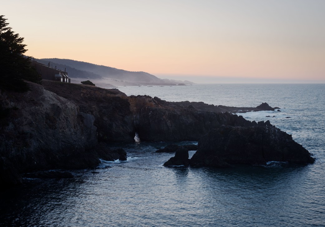 Dawn light illuminating the rugged coastline of The Sea Ranch community with waves breaking against rocky shores