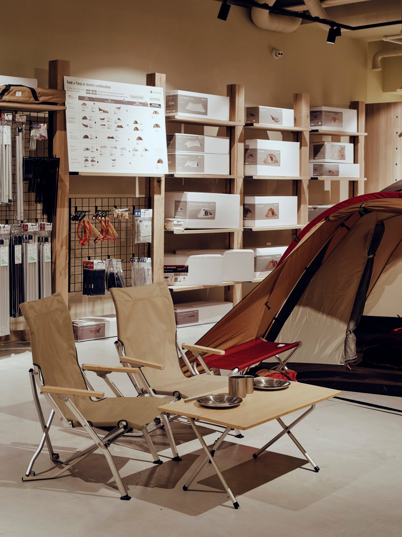 Display of Snow Peak camping equipment including tents and outdoor gear on store shelves