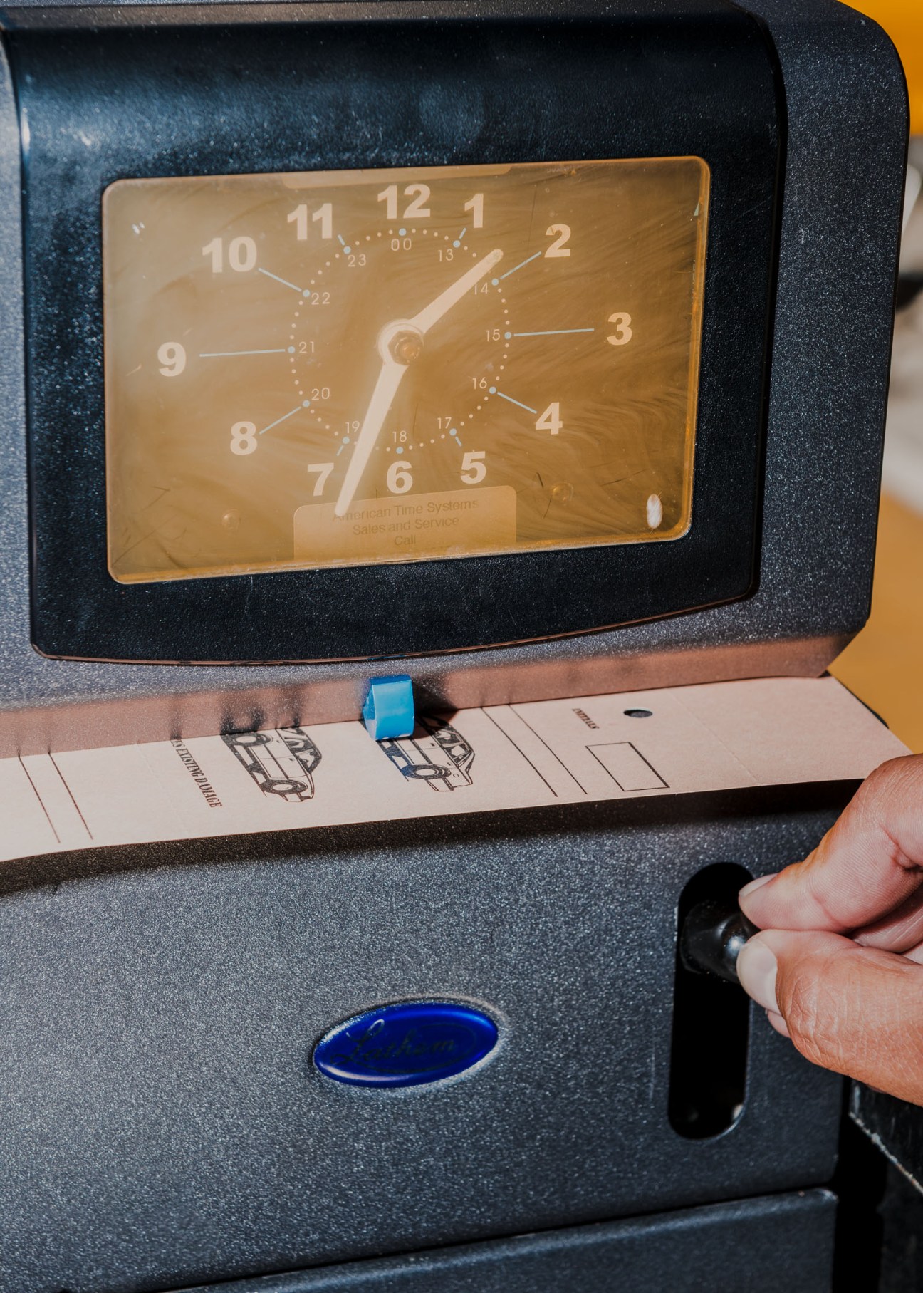 Vintage analog clock above a lockbox with car keys hanging from hooks underneath