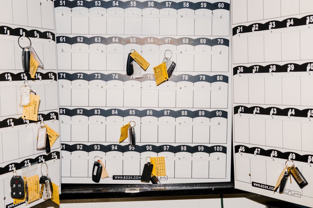 Parking valet key board with numbered slots displaying yellow and black keychains at The Sunset Tower.